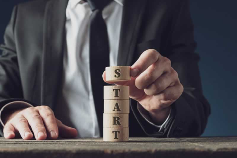 Hombre sujeta piezas que forman la palabra start