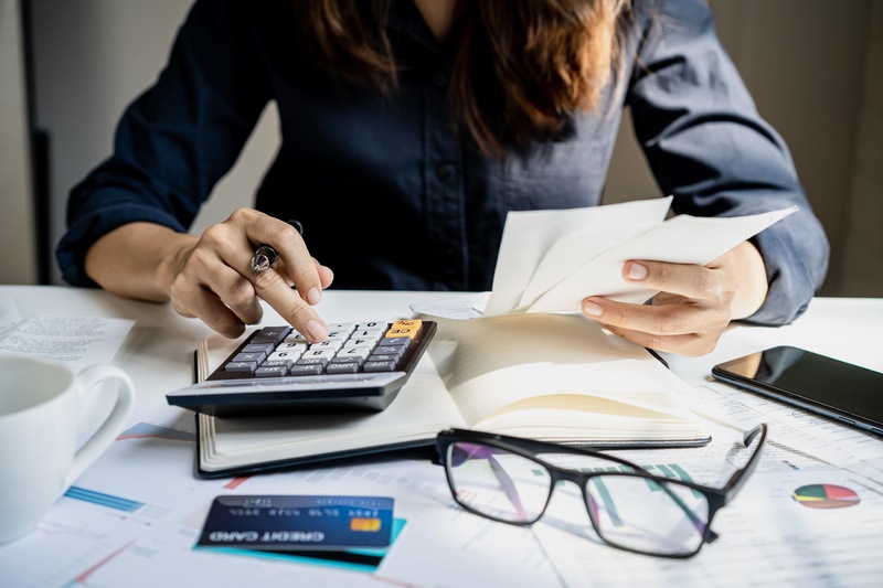 Trabajadora usa calculadora mientras revisa costes de empresa