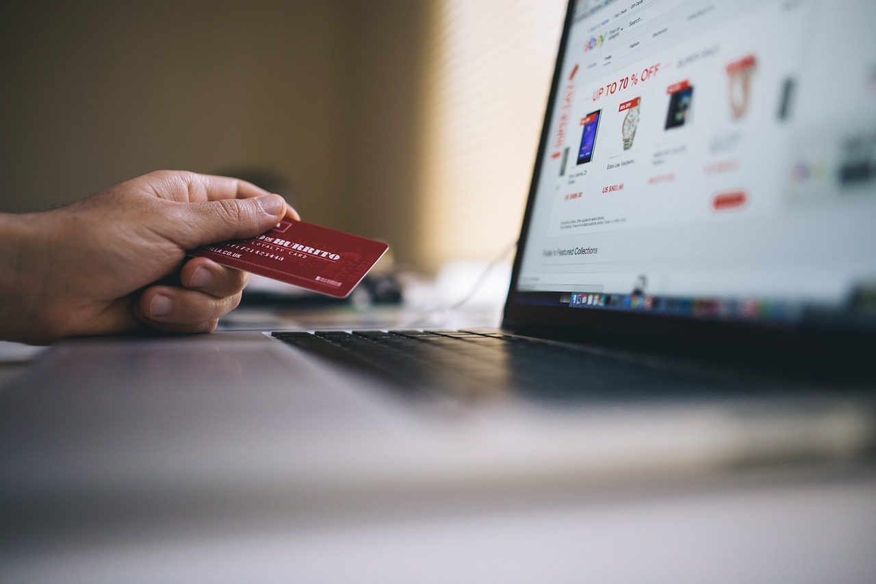 Mano sosteniendo tarjeta de crédito mientras realiza compra online