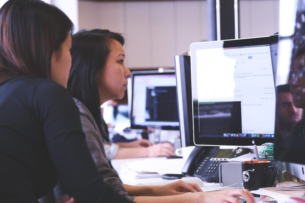 Dos trabajadoras observando la pantalla de un ordenador en oficina