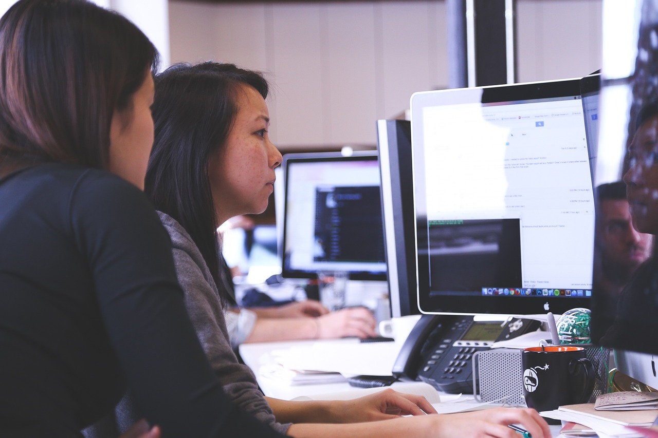 Dos trabajadoras observando la pantalla de un ordenador en oficina